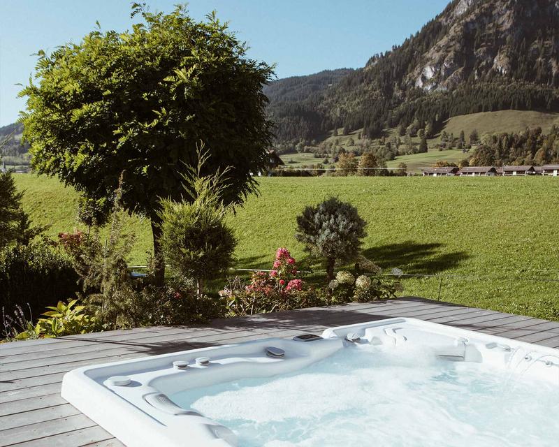 Blubbernder Whirlpool und im Hintergrund eine saftig grüne Landschaft