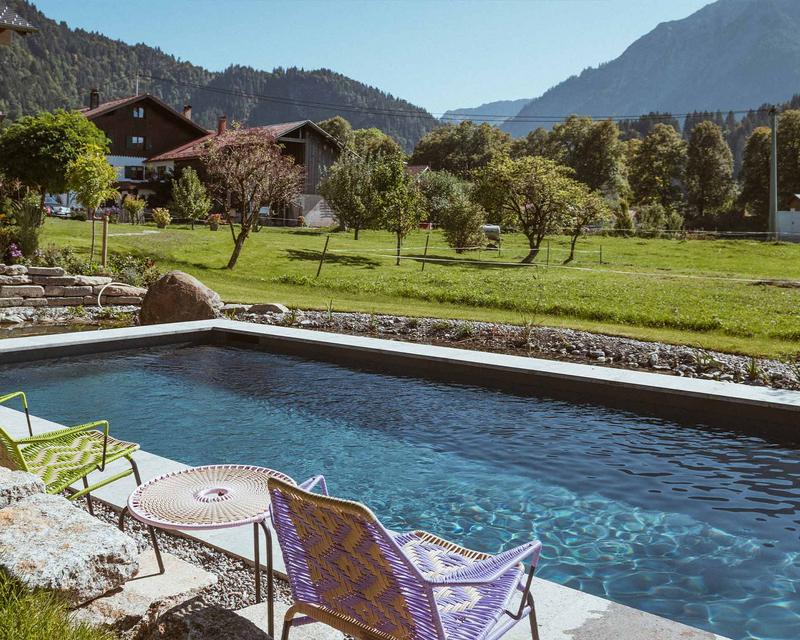 Blauer Pool bei strahlendem Sonnenschein und im Hintergrund das Hindlanger Bergpanorama