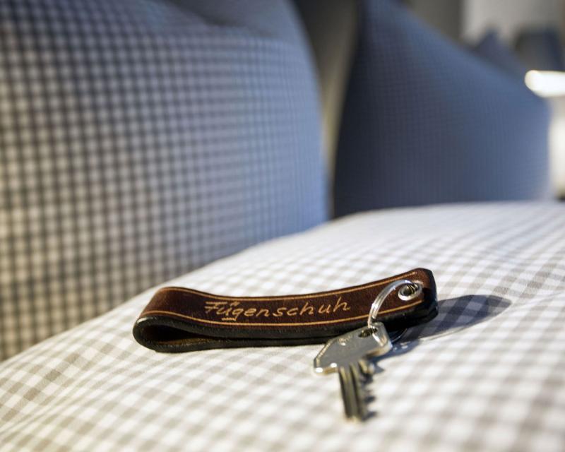 Schlüssel mit Lederschlüsselanhänger auf der Bettdecke liegend