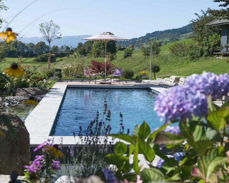 Blauer Pool und im Hintergrund Bergpanorama
