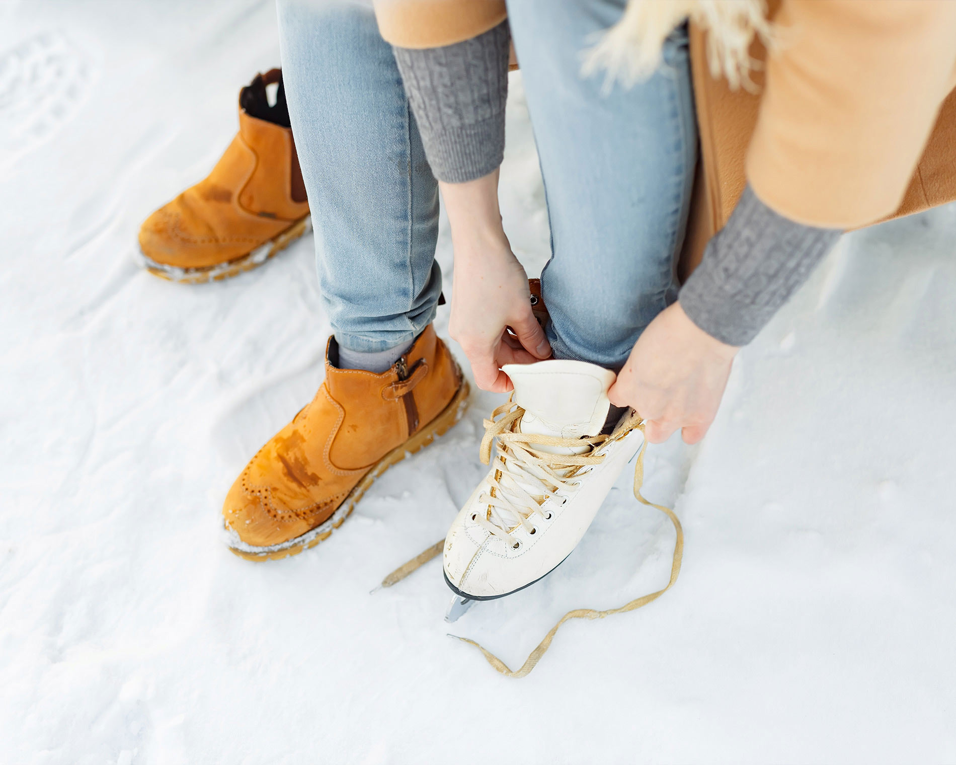 Eine Frau bindet ihre Schlittschuhe
